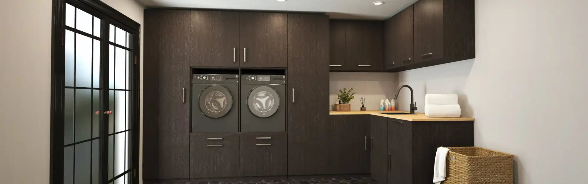 Moderne wasruimte met donkerbruine kasten, geïntegreerde wasmachine en droger, en een gootsteen met een houten aanrecht.